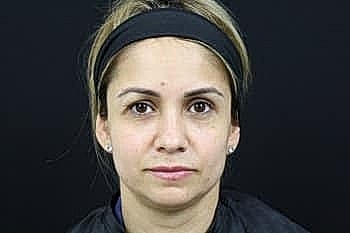 Woman with neutral expression on black background