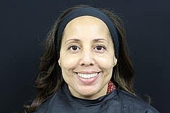 Smiling woman in hair salon setting.