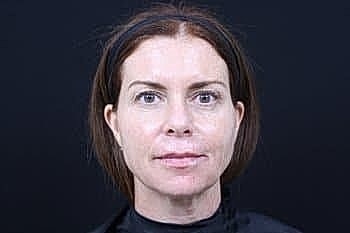 Woman with natural makeup against a dark background