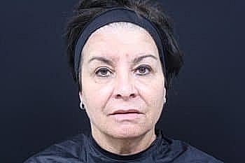 Woman with serious expression against dark background