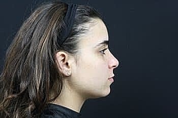 Profile of a young woman against dark background