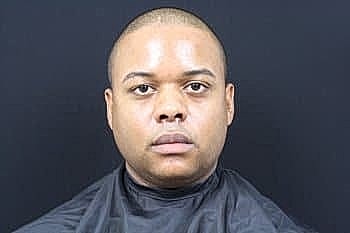 Male portrait with short hair, black background.