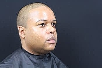 Man with short hair in barber's chair.