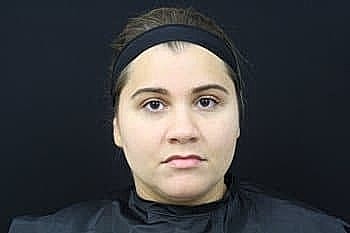 Person with neutral expression against dark background