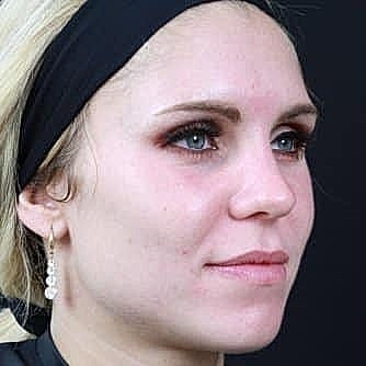 Woman with light makeup and earrings.