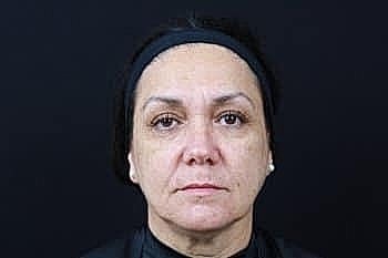 Serious woman against black background portrait.