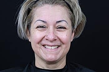 Smiling woman with short, styled hair.