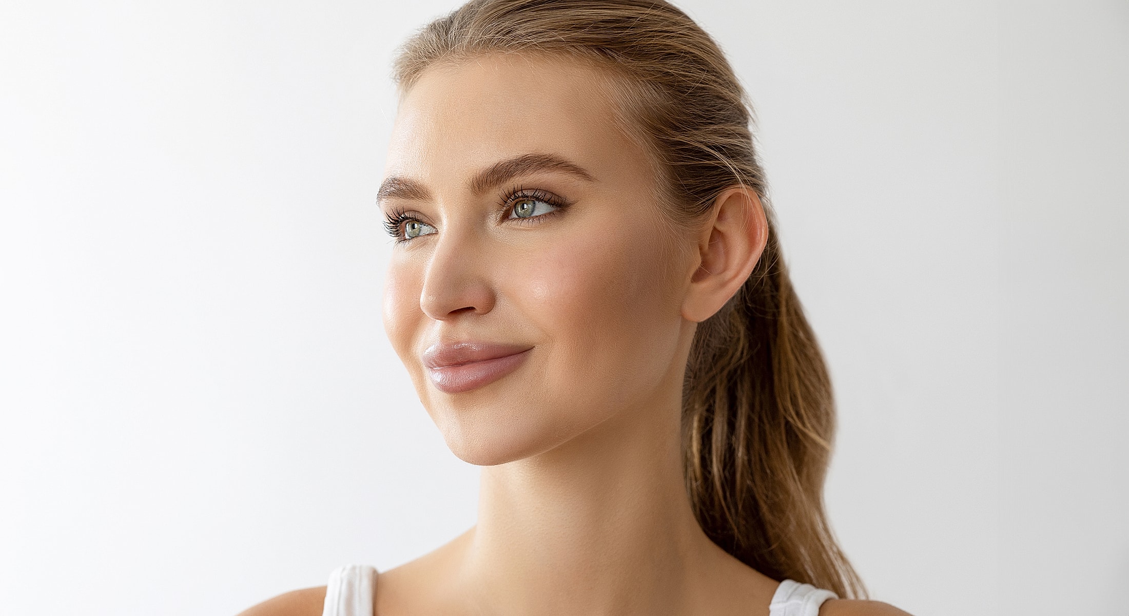 Smiling woman with long hair and natural makeup.