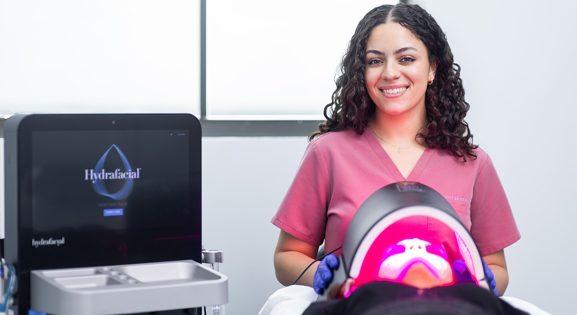 Hydrafacial procedure with technician and equipment display.